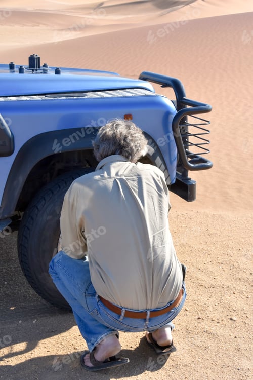 Preview: A Male Tourist Guide Deflating The Tires Of An Offroad Vehicle In The Sand Dunes Near The Coastal