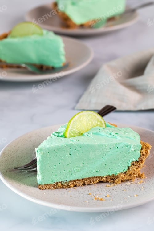 Preview: Vertical View Of A Piece Of Key Lime Pie With Other Pieces In Behind.