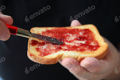 Preview: An Older Man Has Spread Grape Jam On His Buttered Toast