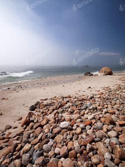 Preview: Scenic View Of Rocks And Stones At Beach With Sea And Clear Sky In Background.
