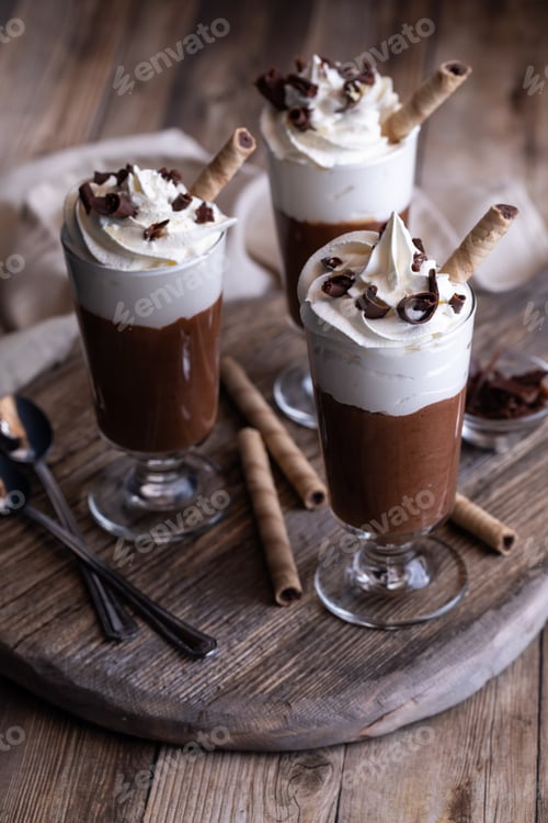 Preview: Three Chocolate Mousse Parfaits With Whip Cream And Chocolate Shavings On A Wooden Board.