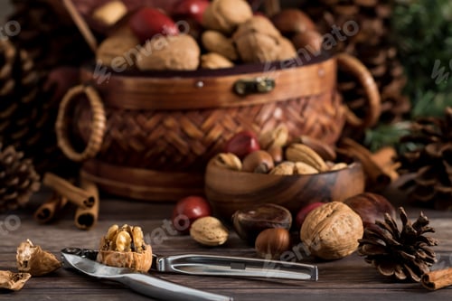 Preview: Front View Of A Basket Of Mixed Nuts With A Small Bowl Of Nuts In Front And A Nut Cracker With A