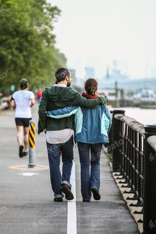 Couple Strolling Along a River Path Together