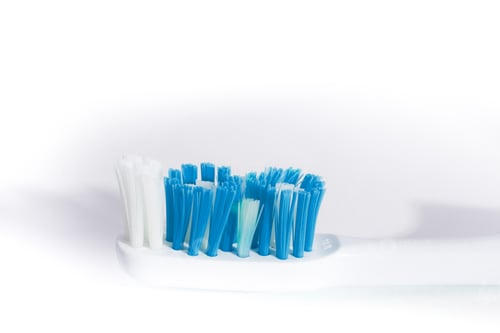 Preview: Macro Closeup Of A Blue And Turquoise Toothbrush On A Textured White Background