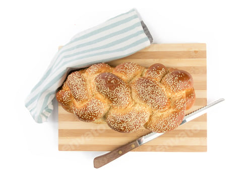Preview: Overhead View Of A Braided Loaf Of Sesame Egg Bread On A Wooden Cutting Board With A Knife Isolated
