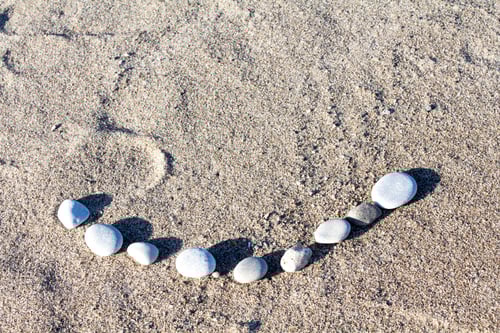 Preview: A Smile Made With Stones In The Sand On A Beach