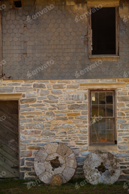Preview: Old Mill Stones Leaning Against A Stone Wall Building In Lancaster County, Pa.