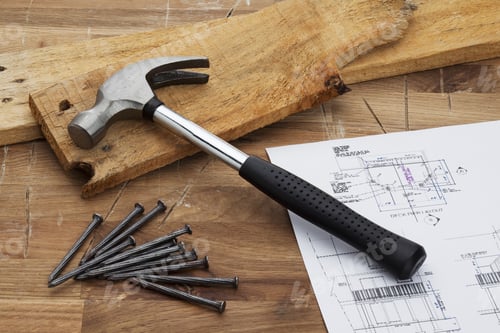 Preview: A Hammer, Nails And Wood Laid Out With Floor Plans