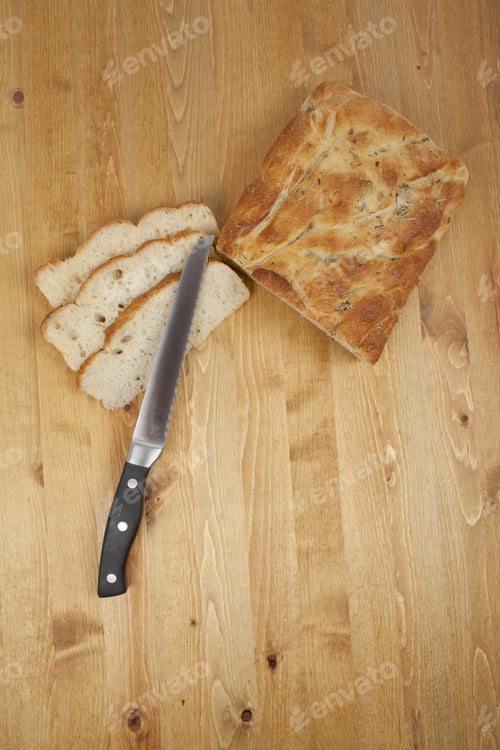 Preview: Top View Shot Of Sliced Bread Loaf And A Bread Knife Over A Wooden Table