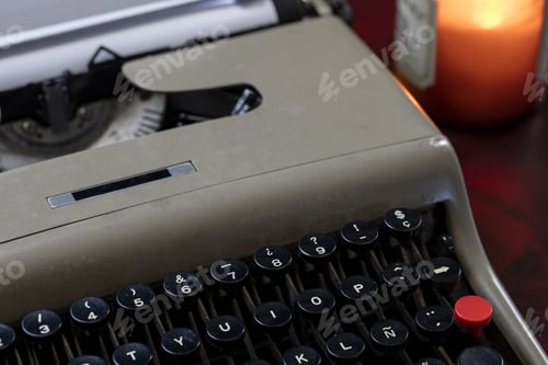 Preview: Vintage Typewriter And Paper On A Table Under Candlelight Ready For The Author To Write A Story.
