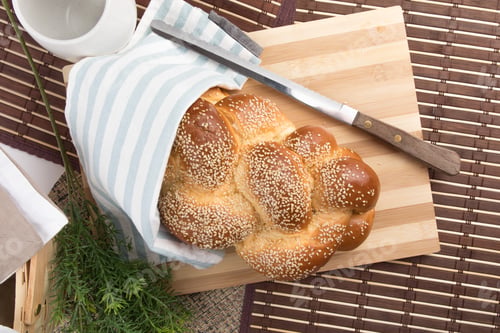 Preview: Overhead View Of A Loaf Of Egg Bread On A Wooden Cutting Board With A Knife