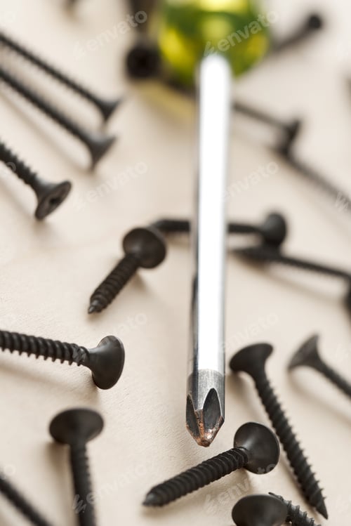 Preview: Screwdriver With Screws On Wood Background