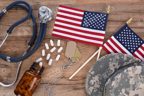 Preview: Military Health Care Concept. Camo Hat, Dog Tags, Stethoscope, Pills, And American Flags On A Wood