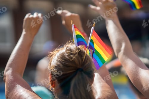 Preview: Brunette Woman In A Crowd Celebrating Pride Parade. Wearing Colorful Rainbow Flags In Her Hair
