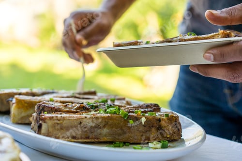 Preview: Succulent Juicy Pork Ribs Sit On A White Plate On The Buffet Line Of A Dinner Party.
