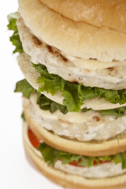 Preview: Cropped Image Of Tall Hamburger With Meat And Vegetables Over The White Background