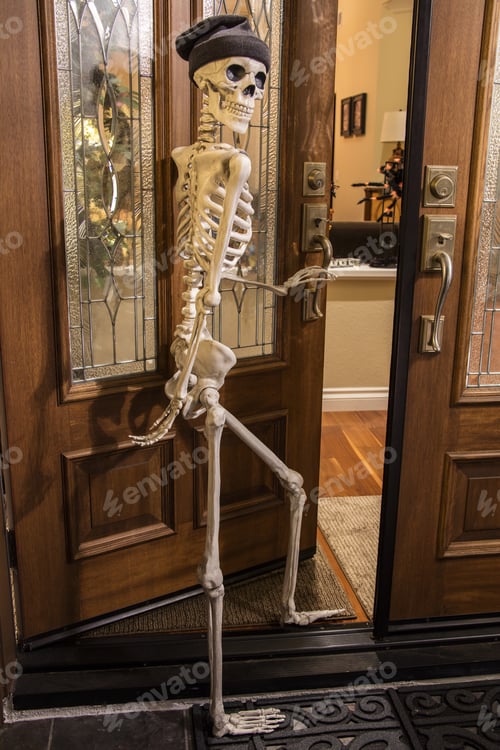 Preview: Halloween Skeleton Greeting At The Door Wearing A Knitted Hat