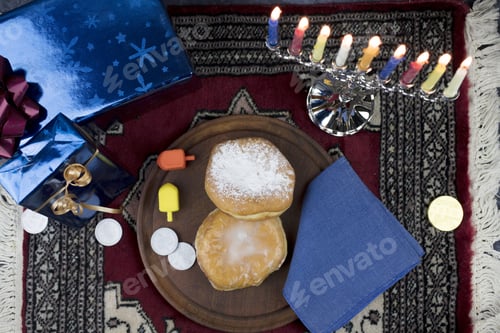 Preview: Hanukkah Menorah With Lit Candles, Gifts, Dreidels And Jelly Filled Pastries Served On A Wooden