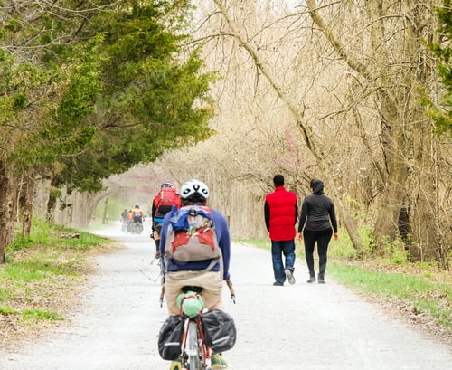 Preview: African-American Young Couple Walking On The Trail In The Fall; Group Of Bicyclists Passing Them On