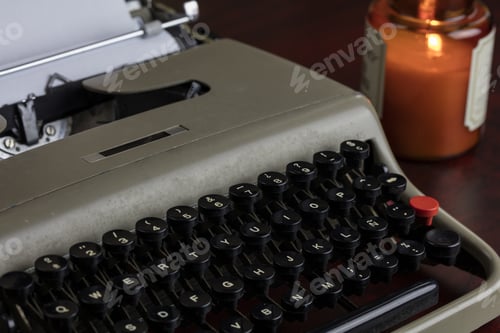 Preview: Vintage Typewriter And Paper On A Table Under Candlelight Ready For The Author To Write A Story.