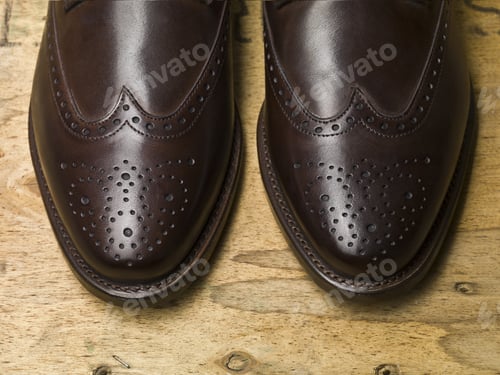 Vista previa: Cropped Image Of Male Brown Shoes Over The Wooden Table