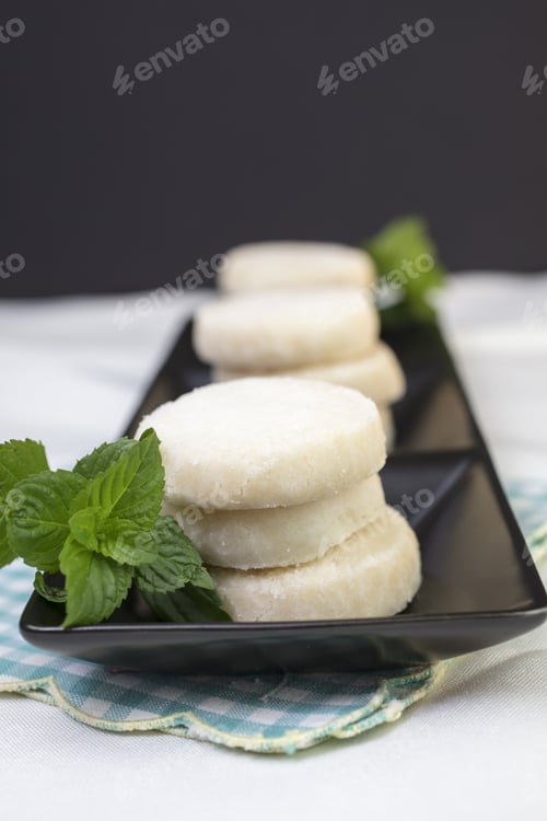 Preview: Lemon And Vanilla Shortbread Cookies Stacked On A Black Ceramic Dish On A Lace Doily And Garnished