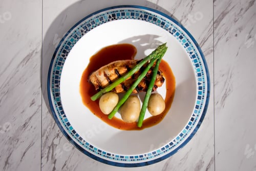 Preview: Overhead View Of Barbeque Chicken Breast With Asparagus And Small Potatoes In A White Dish Set On A
