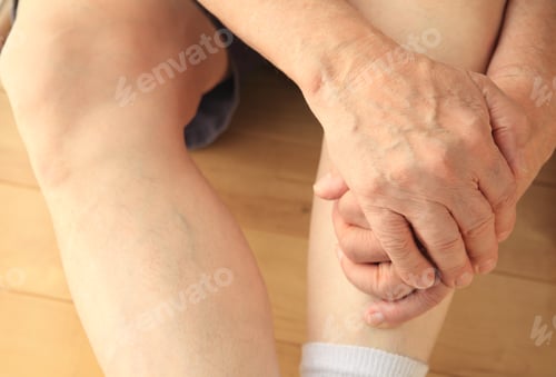 Preview: Man Sitting On Floor With Both Hands On A Leg