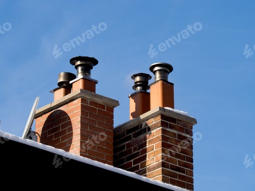 Preview: A Group Of Housetop Fireplace Chimneys With A Satellite Television Antenna Attached