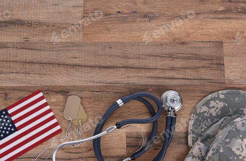 Preview: Military Health Care Concept. Camo Hat, Dog Tags, Stethoscope, Pills, And American Flags On A Wood