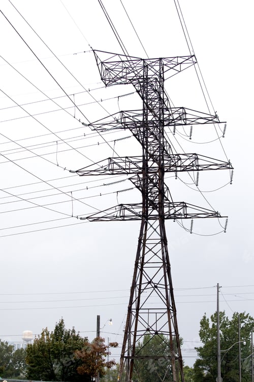 Preview: High Voltage Electric Power Distribution Towers Against A Light Sky