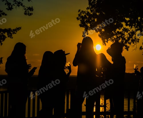 Preview: Dark Silhouettes Of Young Women Enjoying Beautiful Sunset And Drinking Wine On Deck Above Missouri