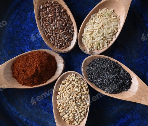 Preview: Closeup Top View Of Five Wooden Spoons Filled With Grains And Spices.