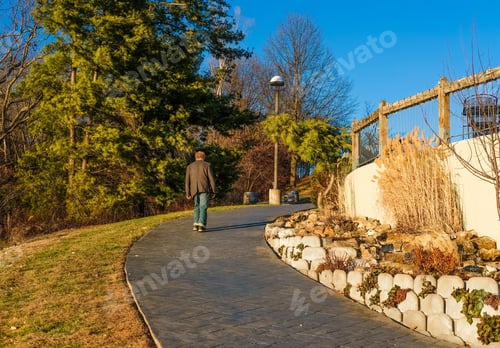 Preview: Older Man Walking Up Footpath In Park On Clear Winter Day In Missouri; Blue Sky In Background