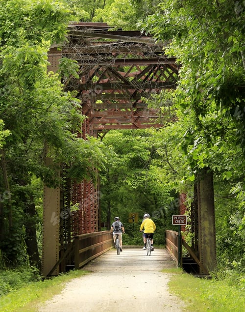 Aperçu: Two Male Bicyclist Riding Under An Old Railroad Bridge; Vertical; Midwest