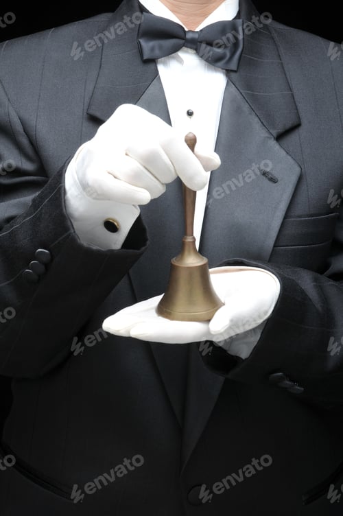 Preview: Butler Holding A Service Bell In Gloved Hand In Front Of Body - Torso Only