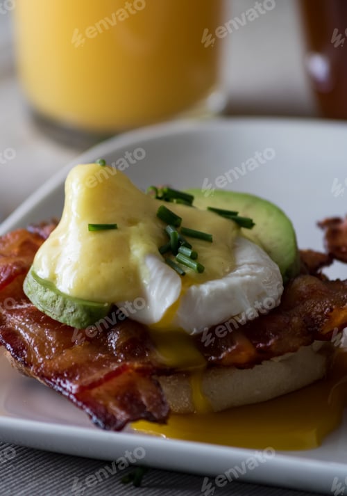 Preview: A Close Up Macro View Of A Serving Of Eggs Benedict With A Glass Of Orange Juice Ready For Eating.