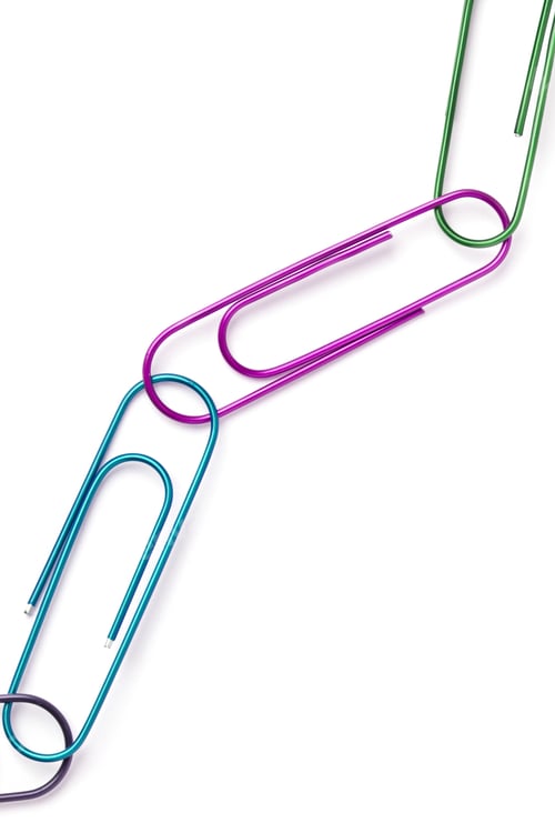 Preview: Close-Up Shot Of Colorful Paperclips Connected To Each Other On White Surface.