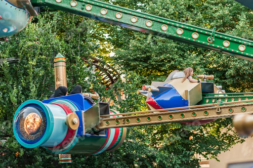 Preview: Child On A Carousel At A Carnival Or Festival At Sunset. Decorative Ornate Spaceships At An