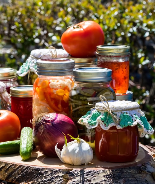 Preview: Close Up Of An Arrangement Of Canned Jars Of A Variety Of Preserves On A Wooden Platter Outdoors In