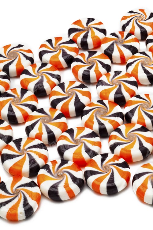 Preview: Close-Up Image Of Colorful Candies With Swirl Pattern Arranged Side By Side Over Plain White