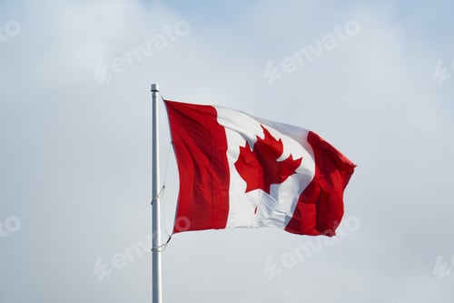 Preview: The Canadian Flag Flying In A Breeze With Light Clouds