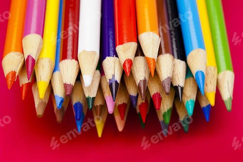 Preview: A Bunch Of Crayons Bundled Together On A Red Background.