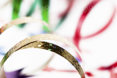 Preview: Extreme Detailed Shot Of A Golden Shiny Streamer With Red And Green Stream In Background.