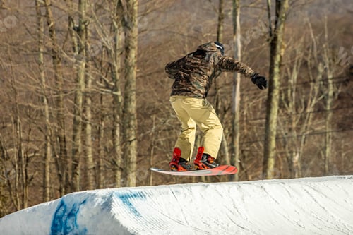 Preview: Snowboarder Having Fun Jumping At Ski Resort In The Air From The Back