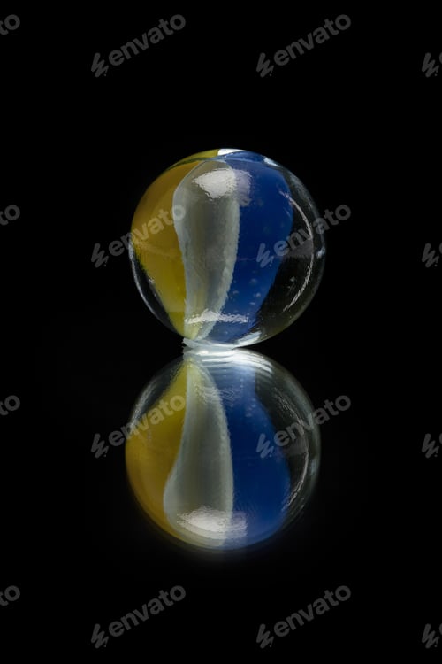 Preview: Close-Up Image Of A Glass Swirl Marble On The Dark Surface