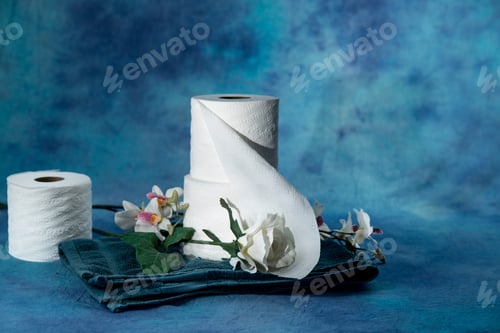 Preview: Rolls Of Toilet Paper With White Flowers On A Dramatic Soft Blue Background