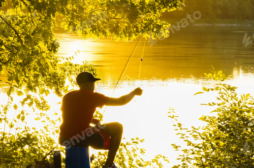 Preview: Young Man Sitting Under The Tree Fishes In A Lake At Sunset In The Fall