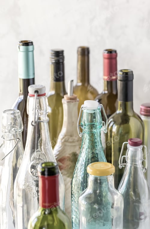 Preview: A Close Up Of Several Different Types And Sizes Of Bottles Against A Bright Background.