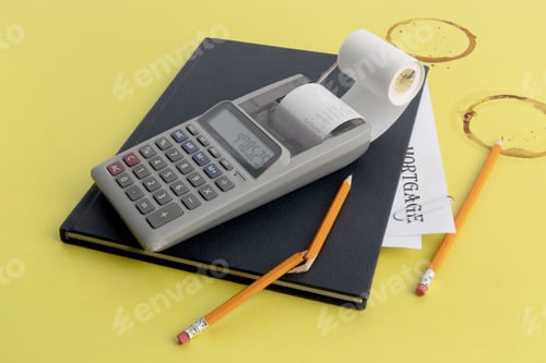 Preview: A Small Calculator A Notebook Of Receipts And A Pencil Broken In Frustration On A Coffee Stained